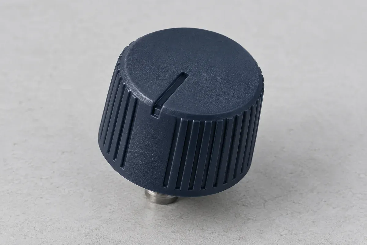Molded grip texture and index notch on a dark plastic knob